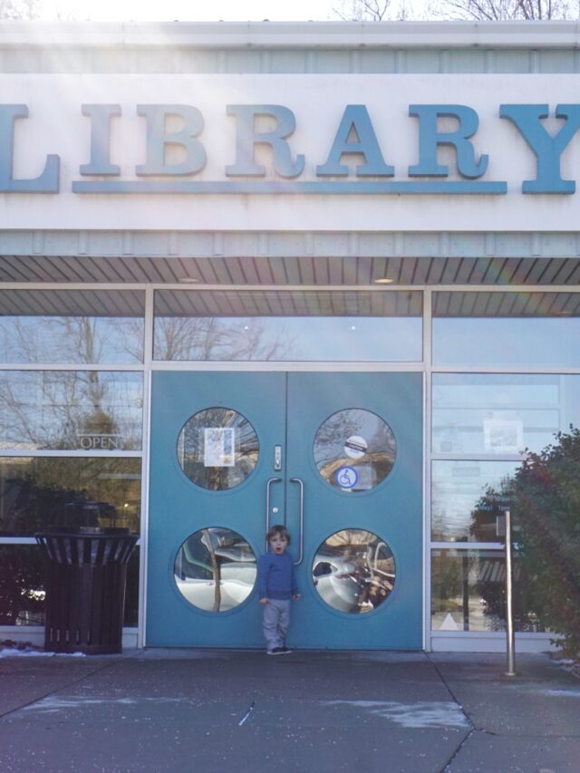 Toddler standing in front of a library entrance